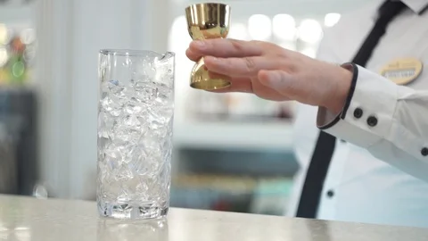 Bartender pours alcohol into a jigger to stir glass Stock Footage 101967547