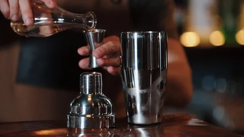 The bartender pours alcohol into a measuring cup and pours it into Jigger. White Stock Footage 129111126