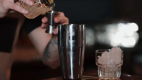 The bartender pours alcohol into a measuring cup and pours it into shaker. Close Stock Footage 129111192