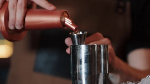 The bartender pours alcohol into a measuring cup and pours it into shaker. Close Vídeo Stock 129111205