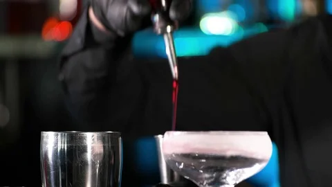 Bartender pours alcoholic drink into small glasses on bar Stock Footage 75346872