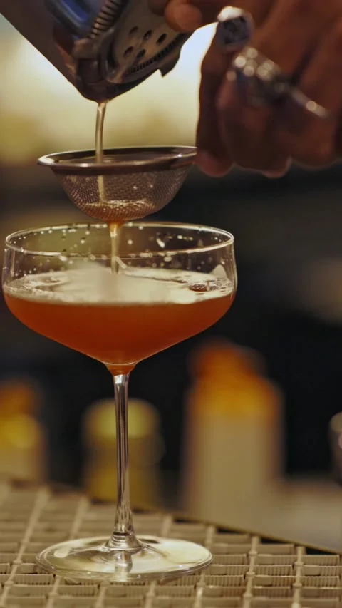 The bartender pours an alcoholic drink through a sieve Stock Footage 329547570