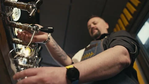 A bartender pours beer into a glass at the bar of a pub. Stock-Footage 233188699