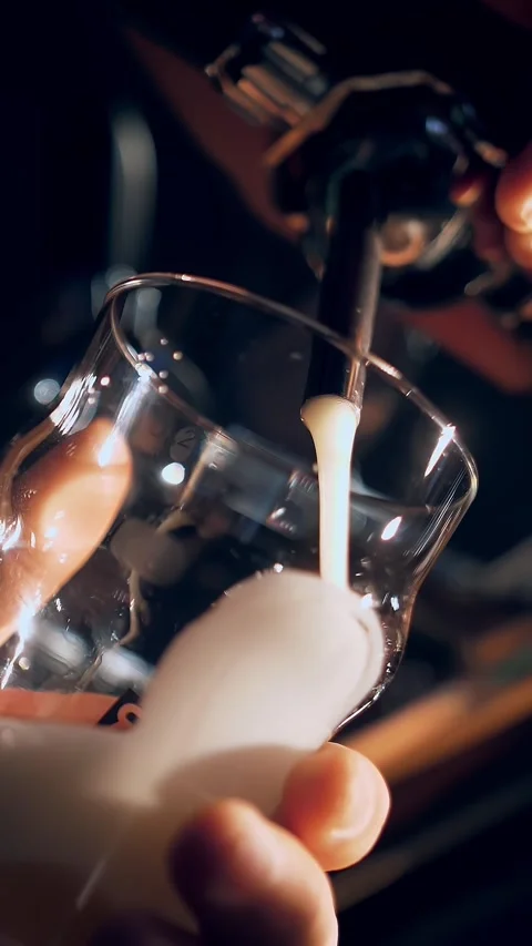 The bartender pours beer into a glass. Close-up view of barman's hand filling Video stock 316781609