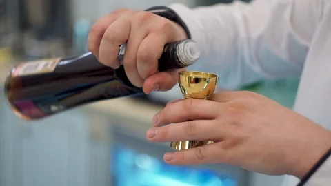 Bartender pours brandy into jigger Video stock 101967727