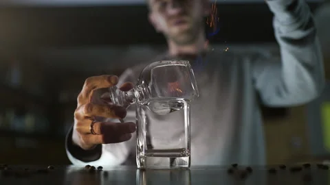 Bartender pours cinnamon powder to the flame of sambuca Stock Footage 143588549