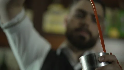 The bartender pours a cocktail from one shaker to anothe Vídeos de archivo 154358039