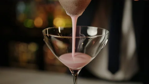 The bartender pours a cocktail through a strainer whipped pink cocktail Stock Footage 219118501