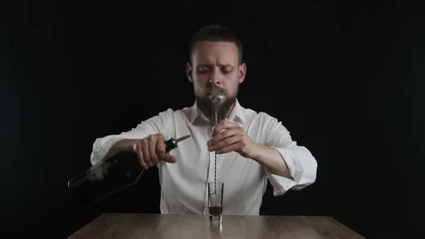 The bartender pours coffee liqueur from a bottle to cocktail glass Stock Footage 132767080