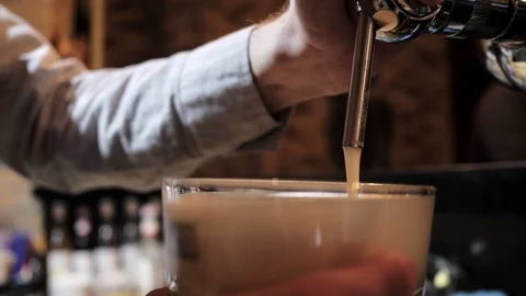 Bartender pours foaming beer holding glass goblet in hand Stock Footage 108311209