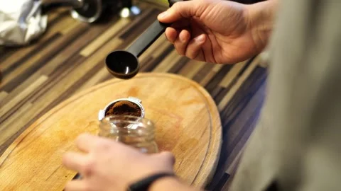 Bartender pours ground coffee into the horn of the coffee machine with a spoon Vídeo Stock 280776598