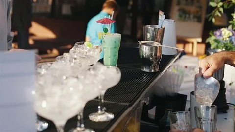 The bartender pours the ice into the glass and pours the turquoise cocktail Stock Footage 73756218