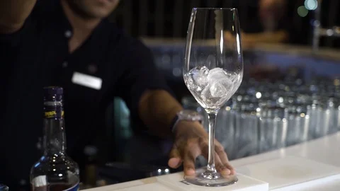 Bartender pours ice into a glass Видео 107890845