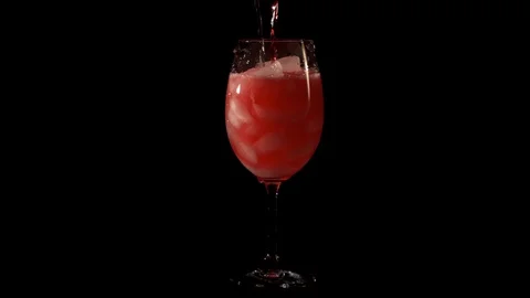 The bartender pours the liquid into an orange cocktail with ice and add a slice Stock Footage 129554432