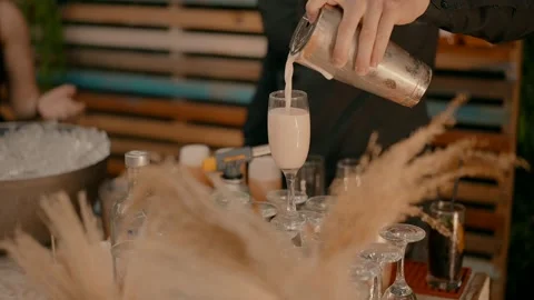 A bartender pours a milkshake into the glass. Video stock 244258911