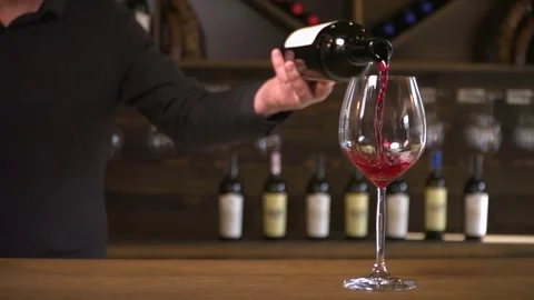 A bartender pours red wine into a glass. Stock Footage 258067636
