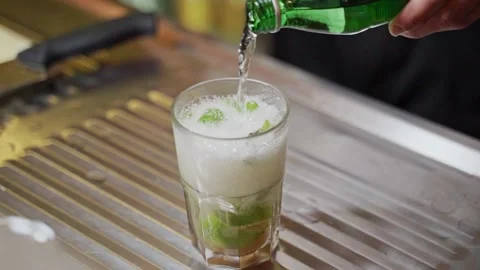 Bartender pours soda into a glass of mojito, making a cocktail. Pouring soda Stock Footage 201876853