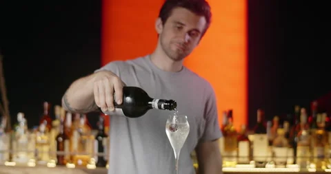 Bartender pours sparkling wine to the high-stemmed glass, barman pours wine in Video stock 157437530
