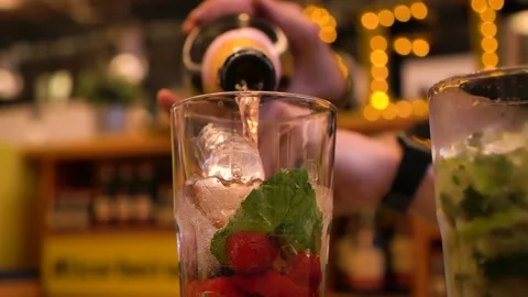 Bartender pours sparkling wine into a refreshing summer cocktail Stock Footage 156512271