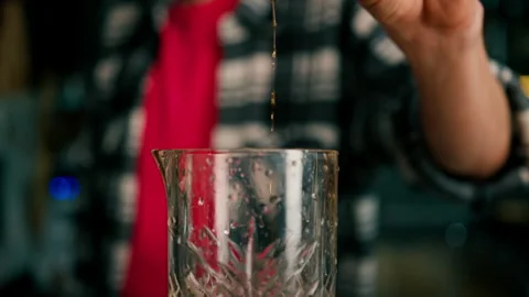 Bartender Pours Red Liquid From Jigger Into Mixing Cup Stock Photo