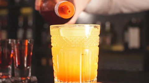 Bartender pours syrup in exotic fruit cocktail Stock Footage 105331653