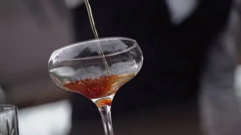 The bartender pours a thin stream of alcohol into a glass Stock-Footage 138583585