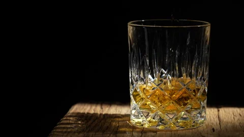 Bartender pours  whiskey from bottle into crystal glass, close up Stock Footage 293235012