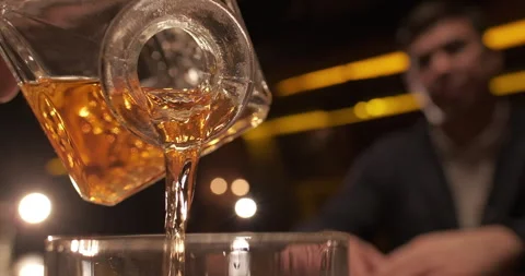The bartender pours whiskey from the decanter. Enjoy fine alcoholic drinks Stock Footage 256929449