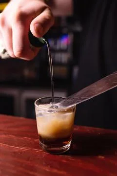 Bartender prepares B52 Shot. Making cocktails at a party, close-up Stock Photos