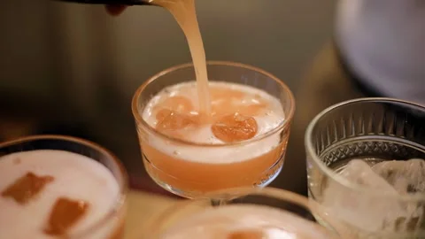 The bartender prepares a cocktail by pouring the ingredients into a glass Stock Footage 329372632