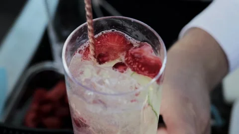 Bartender prepares a delicious cocktail with lemonade, cucumber and strawberry Stock Footage 314887562