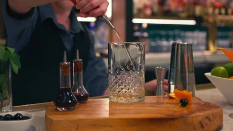 Bartender prepares elegant old fashioned cocktail at a classy modern hotel bar 動画素材 280494767