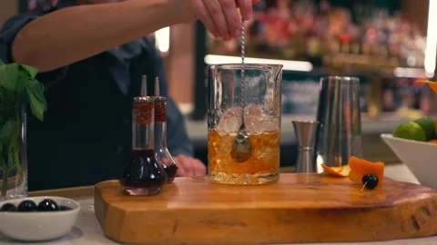 Bartender prepares elegant old fashioned cocktail at a classy modern hotel bar Stock Footage 280494771