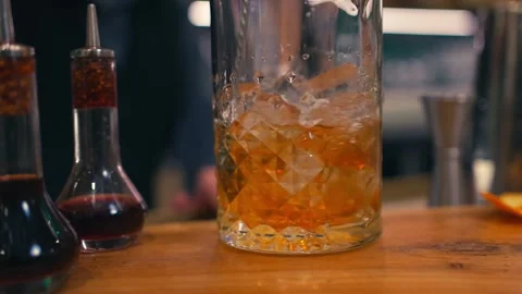 Bartender prepares elegant old fashioned cocktail at a classy modern hotel bar Stockbeeldmateriaal 280494780
