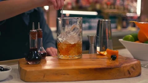 Bartender prepares elegant old fashioned cocktail at a classy modern hotel bar Video stock 280494784