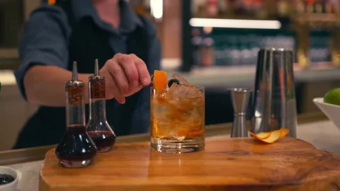 Bartender prepares elegant old fashioned cocktail at a classy modern hotel bar Stock Footage 280494785