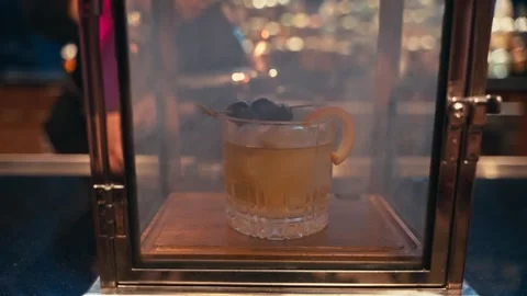 Bartender prepares elegant smoked old fashioned cocktail whiskey drink smoker Vidéo 280507785
