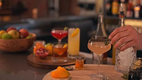 Bartender prepares modern cocktail in martini glass with garnish cinematic Stock Footage 280514703