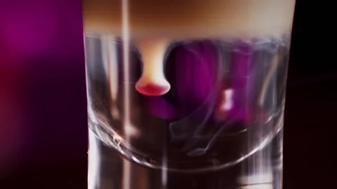 The bartender prepares a multi-layer cocktail in a glass, dripping liquor Vídeo Stock 159140142