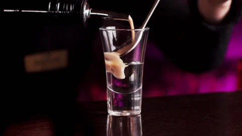 The bartender prepares a multi-layered cocktail in a glass Vídeo Stock 159140050