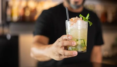 Bartender prepares preparing refreshing Mojito drink closeup Stock Photos