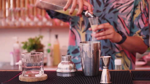 The bartender is preparing an alcoholic cocktail and pouring lemon juice. Stock Footage 186948436