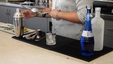 Bartender preparing Blue lagoon cocktail sitting near shaker, jigger, bar s.. Stock Footage 315531057