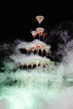 Bartender preparing a champagne tower with dry ice and cherries at an elega.. Stock Photos