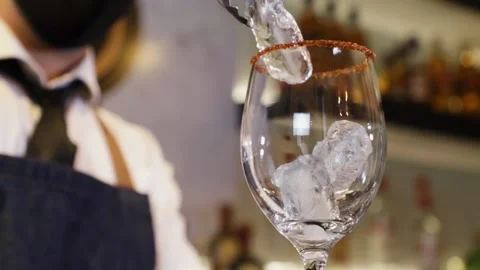 Bartender preparing a cocktail on a bar counter. Making ice with a metal tong Stock Footage 147680260