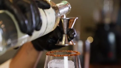 Bartender preparing a cocktail on a bar counter. By pouring alcoholic beverag Stock Footage 147680270