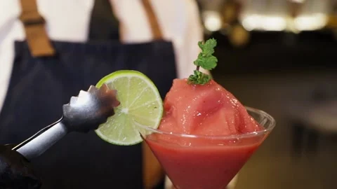 Bartender preparing a cocktail on a bar counter. Placing with a metal clamp a Stock Footage 147680321