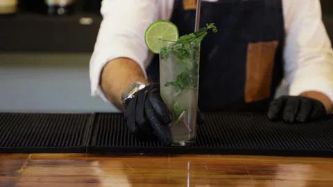 Bartender preparing a cocktail on a bar counter. putting the ready Mojito coc Stock Footage 147680327