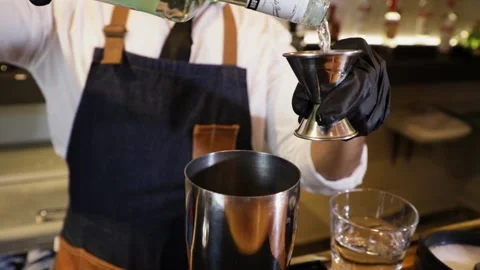 Bartender preparing a cocktail on a bar counter. Making alcoholic beverage fr Stock Footage 147680330