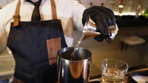 Bartender preparing a cocktail on a bar counter. Making alcoholic beverage fr Stock Footage 147680337
